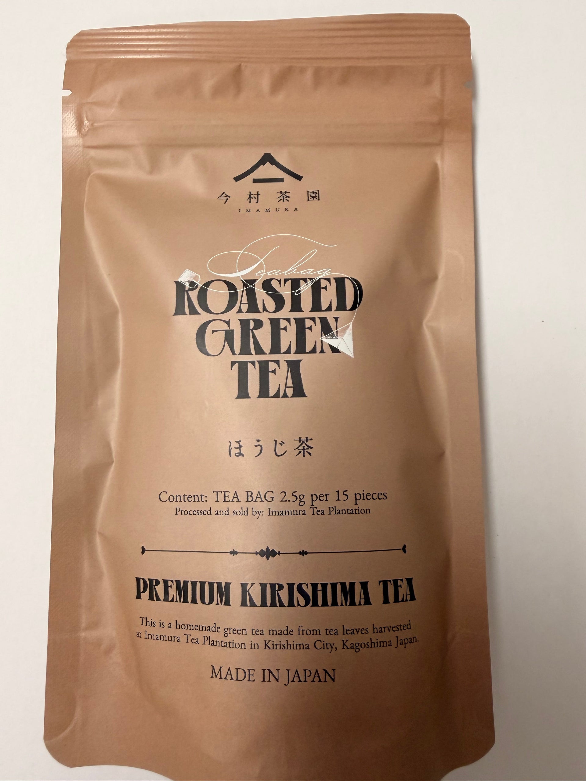 Brown package of roasted green tea with text on a white background